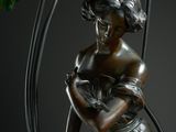 bronze sculpture of a woman holding a cat in a cage