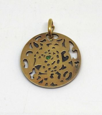 une image représentant un pendentif en or orné d'une pierre verte au centre