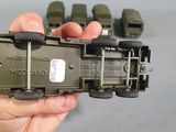 a person holding a toy army truck in their hand
