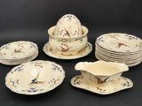 many plates and bowls with birds on them on a table