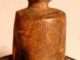 a wooden figurine sitting on top of a table next to a pair of scissors