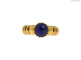 un gros plan d'une bague en or sertie d'un lapis-lazuli