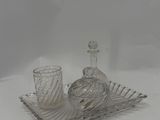 a glass tray with a bottle and a glass cup on it