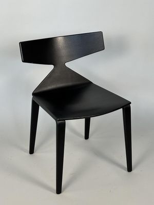 La chaise est en bois et son assise est noire.