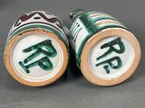 two green and white salt and pepper shakers with chinese characters on them