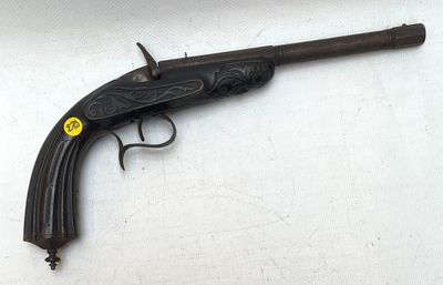 gros plan d'un pistolet sur une table à fond blanc