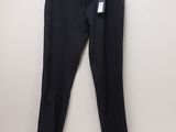 un pantalon noir suspendu à un cintre devant un mur blanc