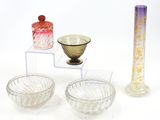 three glass bowls and a vase sitting on a table