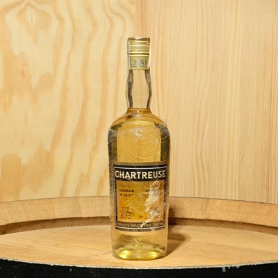 a bottle of chartreuse sitting on top of a barrel