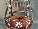 a small wooden chair with a flower pot in it