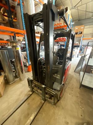 un chariot élévateur dans un entrepôt rempli de palettes