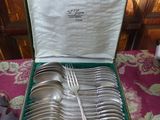 un coffret vert contenant de l'argenterie sur une table