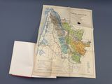 un livre ouvert sur lequel sont posés une carte et un stylo