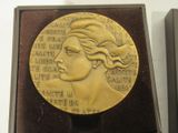 a gold medal with a woman ' s face on it