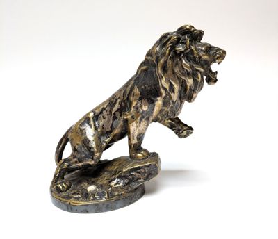 statue of a lion on a rock on a white background