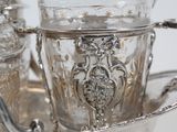a silver plate with a silver tea set on it