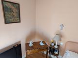une chambre avec un lit, un bureau et un tableau accroché au mur