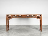 une table en bois dont le plateau est orné d'un motif sculpté