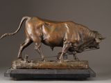 bronze statue of a bull on a wooden base on a gray background