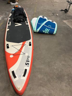 une planche de surf rouge et blanche posée sur un parking
