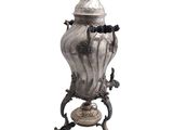 an image of a silver vase with a lid on a stand