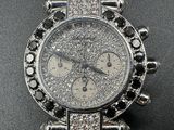 a silver watch with diamonds on it on a black surface