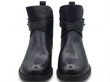 une paire de bottines en cuir noir avec des boucles, sur fond blanc