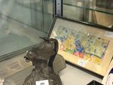 une vitrine en verre sur laquelle sont posés un vase et des photos
