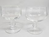 two clear glass goblets sitting on top of a white table