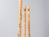 two wooden flutes are sitting on a stand on a gray surface