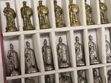 a lot of silver and gold figurines in a display case