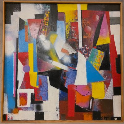tableau représentant des formes et des couleurs abstraites, encadré dans un cadre en bois et accroché au mur