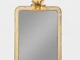 un miroir à cadre doré accroché à un mur blanc et orné d'un décor à la feuille d'or