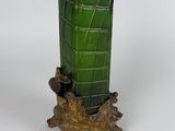 a green vase sitting on top of a tree stump