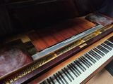 a piano that is sitting on a table in a room