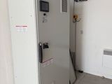 a white refrigerator with a fan on top of it in a room
