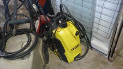un compresseur jaune et noir et des tuyaux dans une pièce