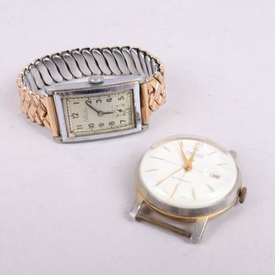 une montre en argent et une montre en or posées sur une surface blanche