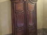 une grande armoire en bois dans un coin d'une pièce