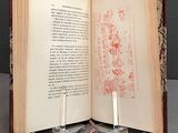 a open book with a candle on it sitting on a table