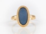 a close up of a gold ring with a blue stone in it