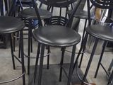 a lot of black stools that are sitting on the floor