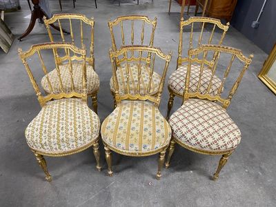 four antique chairs with upholstered seats in a room with a mirror on the wall
