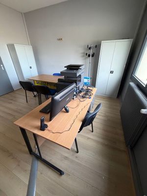 un bureau sur lequel se trouvent un ordinateur et une imprimante, dans une pièce