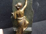 a bronze statue of a woman holding a plaque