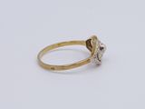an image of a diamond and gold ring on a white surface