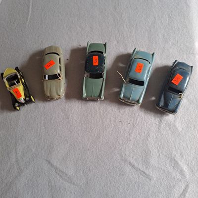 plusieurs petites voitures sont alignées sur une surface blanche