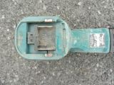 a broken parking meter sitting on the ground on the street
