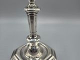 a close up of a silver candle holder on a table