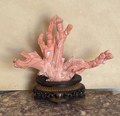 une statue représentant une femme, posée sur un socle posé sur une table